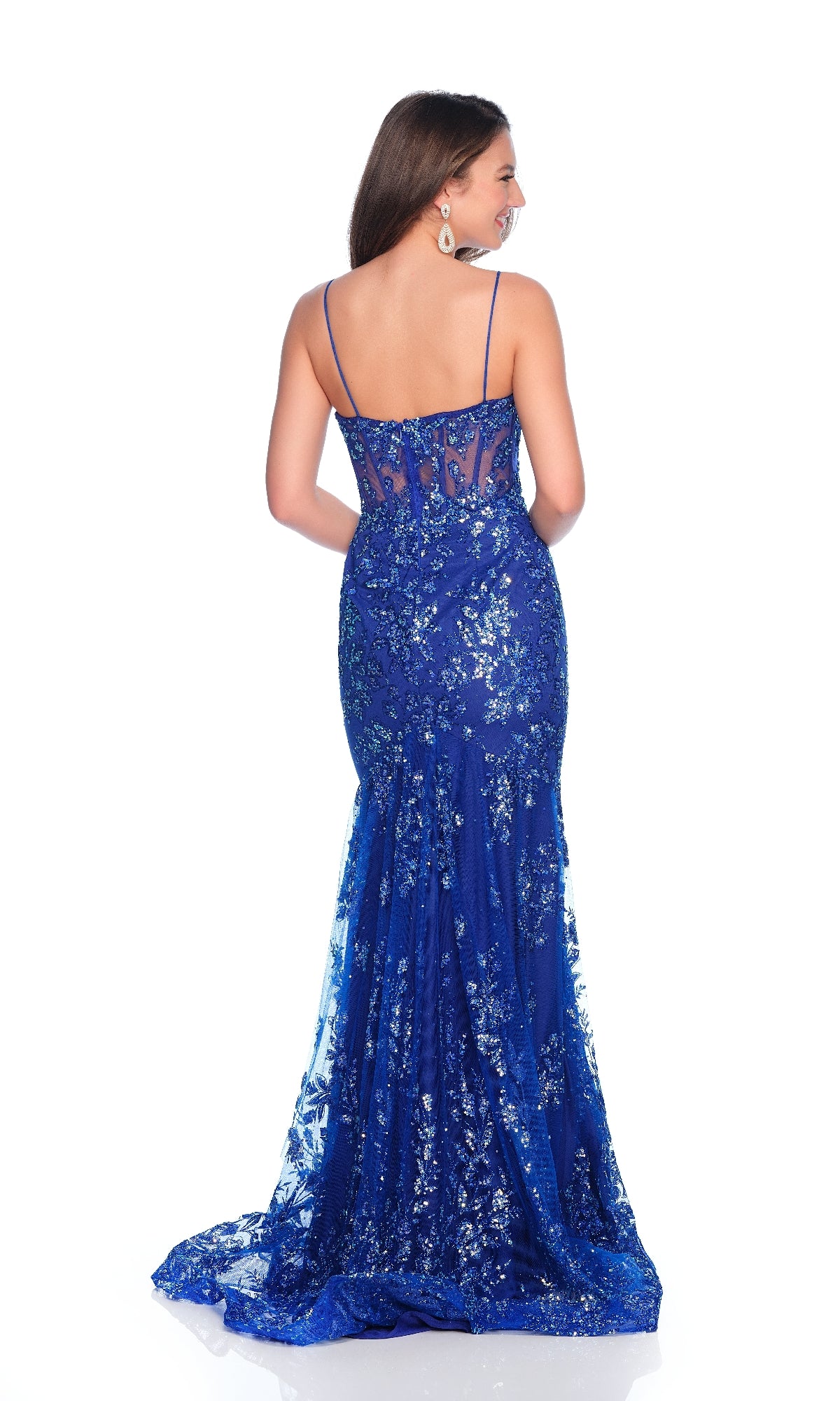 A woman faces away, revealing the illusion lace back of the Dave & Johnny 12144 long royal blue prom dress with thin straps and a floral sequin print.